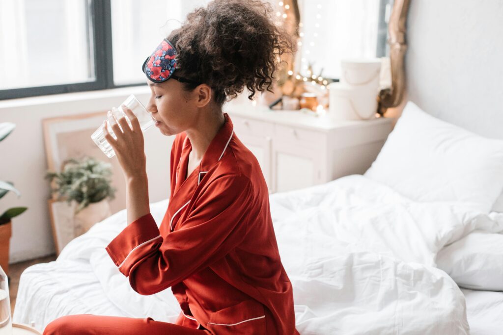 "woman drinking water after waking up"